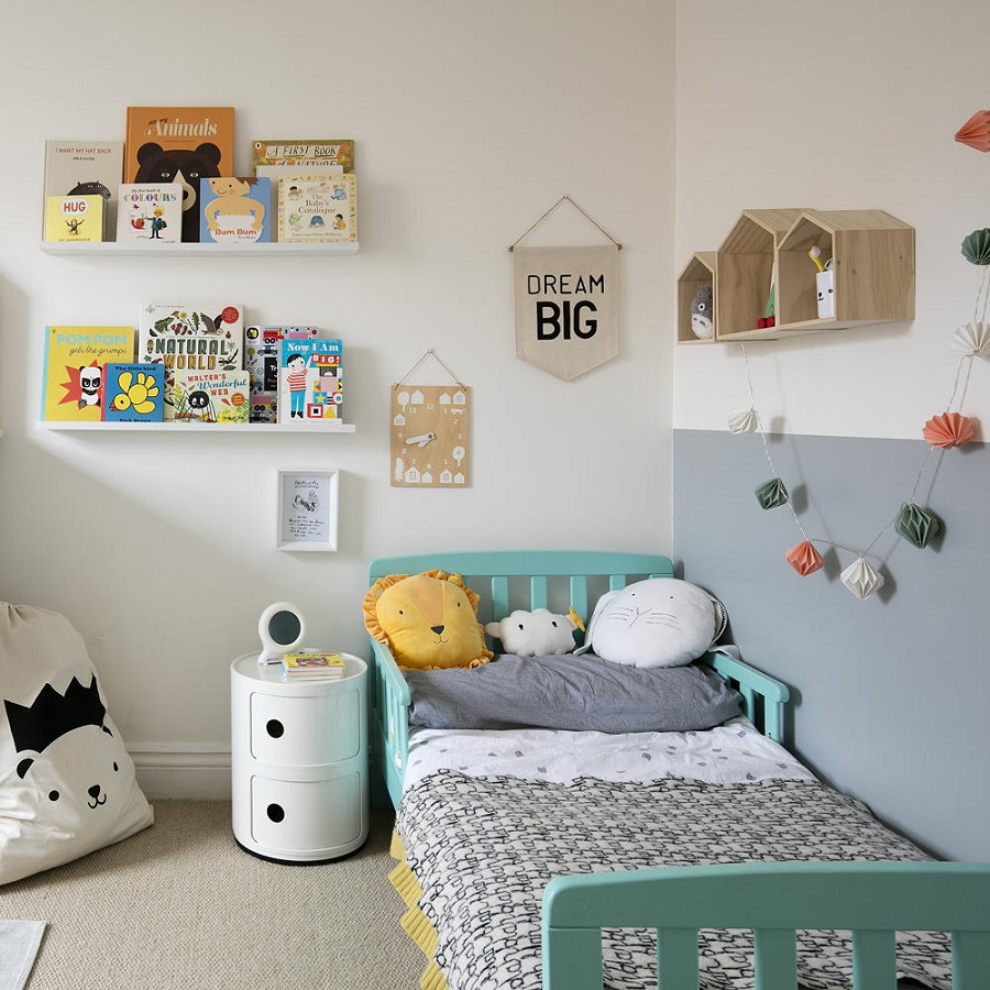 Mẫu thiết kế dành cho gia đình có diện tích phòng ngủ khiêm tốn có thể tham khảo. Căn phòng sử dụng các chi tiết khá đơn giản như giá treo, một vài cái gối bông ngộ nghĩnh cùng một chiếc giường màu xanh điểm thêm dây hoa bằng giấy rất phù hợp với sở thích của trẻ ở độ tuổi lên 2.